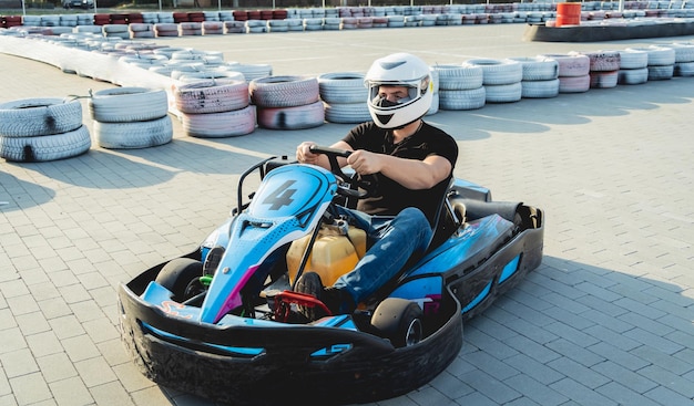 A young man drives a go kart at circuit