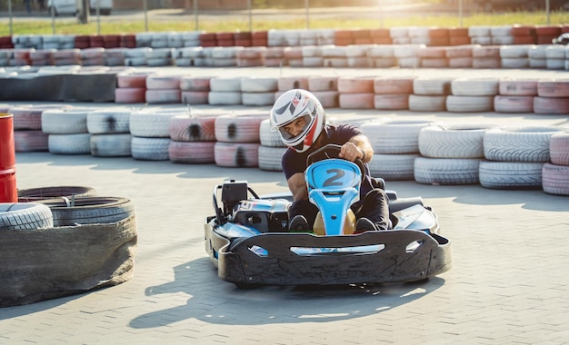 A young man drives a go kart at circuit