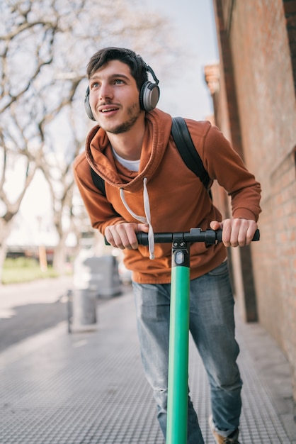 Young man driving electric scooter.