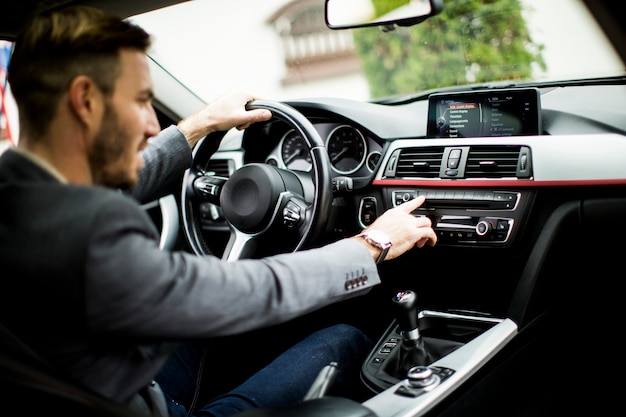 現代の車で運転している若い男