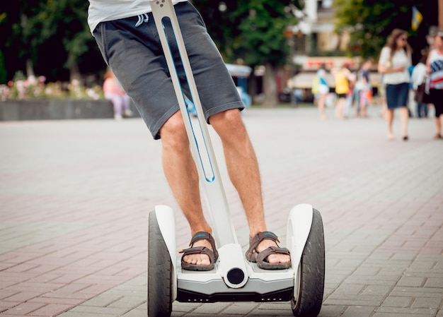 Young man driving on segway in the park