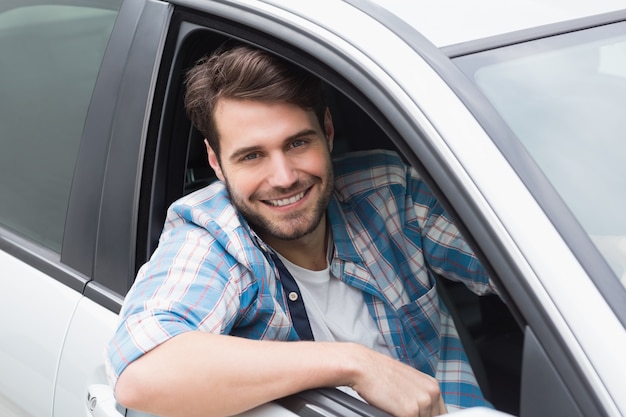 Young man driving and smiling