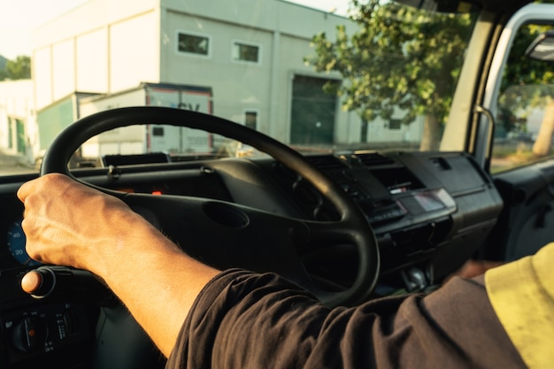 Young man driving a truck inside the cabin with the security clothes