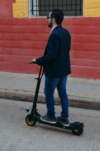 Giovane in uno scooter elettrico mentre va al lavoro, di fretta