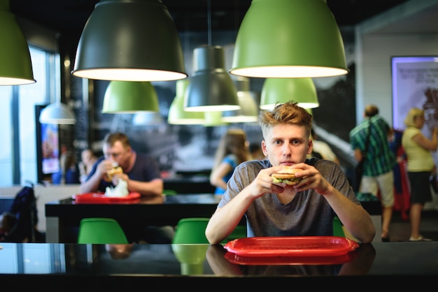 Young man eating a delicious hamburger