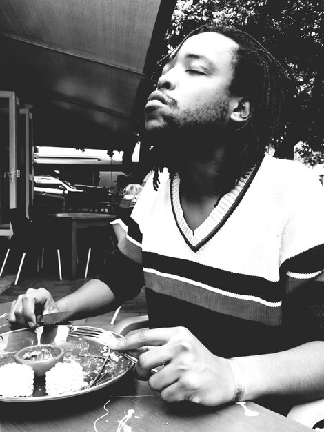 Photo young man eating food in restaurant