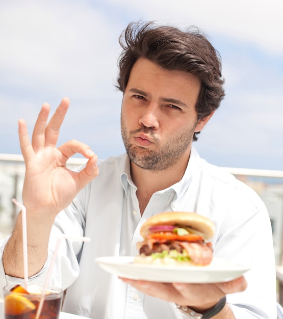 Young man eating a hamburguer