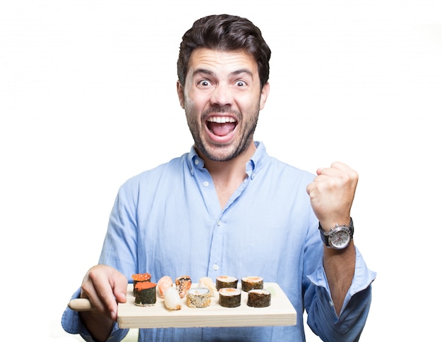 Young man eating sushi on white background