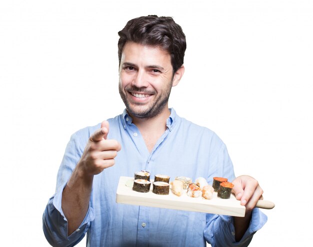 Young man eating sushi on white background