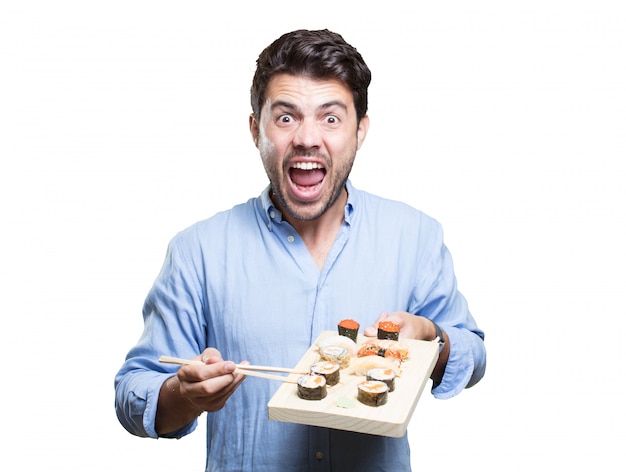 Young man eating sushi on white background