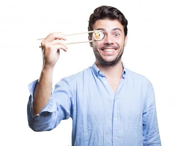 Young man eating sushi on white background