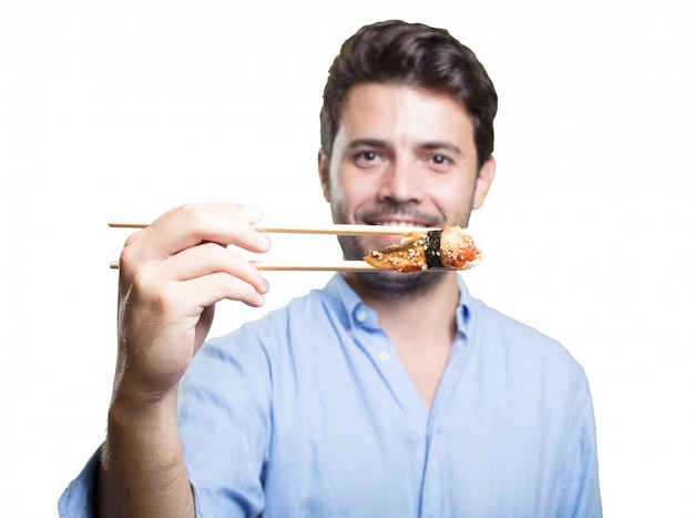 Young man eating sushi on white background