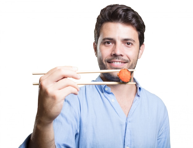 Young man eating sushi on white background