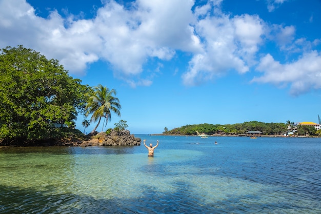 A young man enjoying in the Caribbean Sea on West End Beach on Roatan Island. Honduras