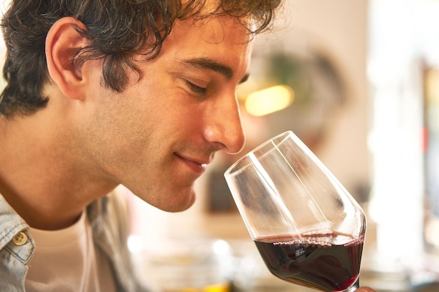 Young man enjoys wine tasting at bar counter