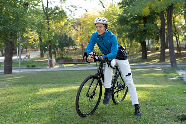 A young man of European appearance sat down on a bicycle frame. active lifestyle.