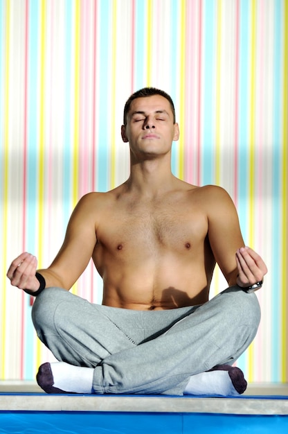 young man exercise and practice yoga fitness  in lotus position indoor