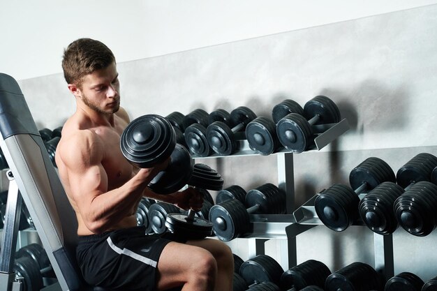 Photo young man exercising at gym