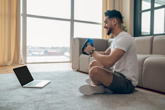 Young man exercising at home with expander