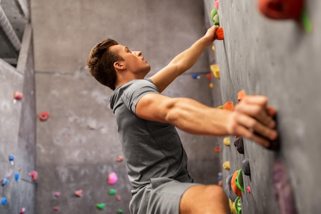 Foto giovane uomo che si esercita in una palestra coperta per l'arrampicata