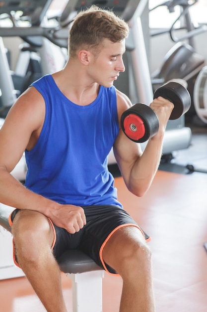 young man exercising lifting weight at the gym