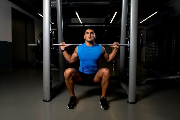 Young man exercising with barbell Squats