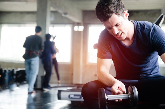 Foto giovane che si esercita con il manubrio in palestra