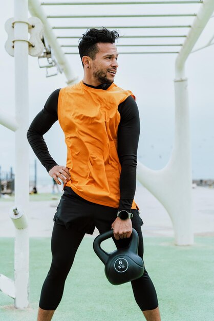 Photo young man exercising with kettlebell in gym