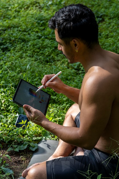 Young man explaining drawing on his ipad tablet while teaching chakra yoga and meditation class mexico