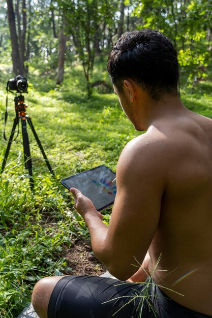 Young man explaining drawing on his tablet while teaching chakra yoga and meditation class mexico