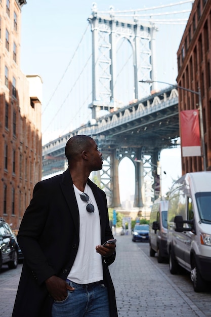 Photo young man exploring city while using smartphone