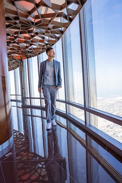 Young man exploring dubai city from burj khalifa skyscraper