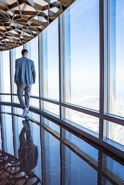 ブルジュハリファの超高層ビルからドバイの街を探索する若い男