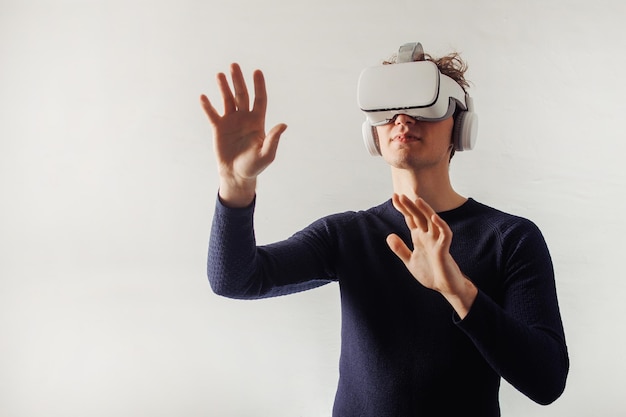 Young man exploring new universe with VR glasses