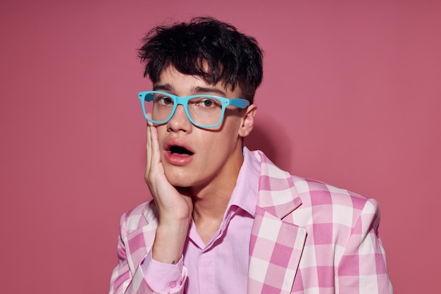 Молодой человек в модных очках розовый блейзер позирует в студии на розовом фоне без изменений