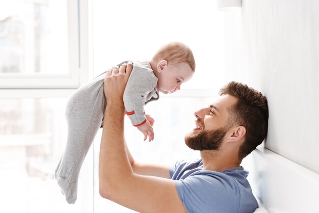 Young man father dad having fun with his little baby