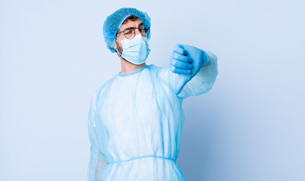 Young man feeling cross, angry, annoyed, disappointed or displeased, showing thumbs down with a serious look. coronavirus concept