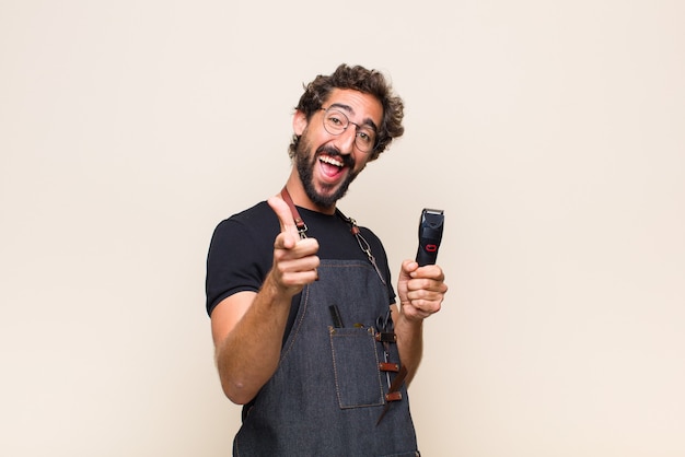 Young man feeling happy, cool, satisfied, relaxed and successful, pointing to front, choosing you