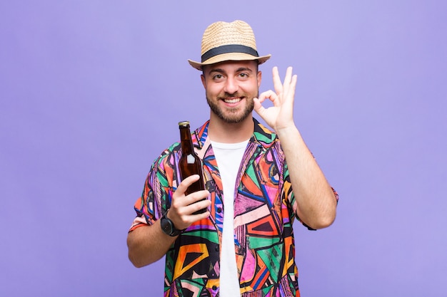 Young man feeling happy, relaxed and satisfied, showing approval with okay gesture, smiling