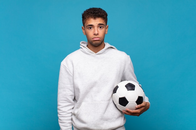 Young man feeling sad and whiney with an unhappy look, crying with a negative and frustrated attitude. soccer concept