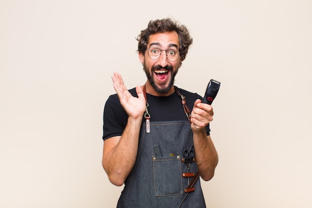 Young man feeling shocked and excited, laughing, amazed and happy because of an unexpected surprise