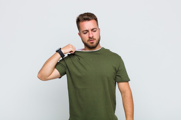 Young man feeling stressed, anxious, tired and frustrated, pulling shirt neck, looking frustrated with problem