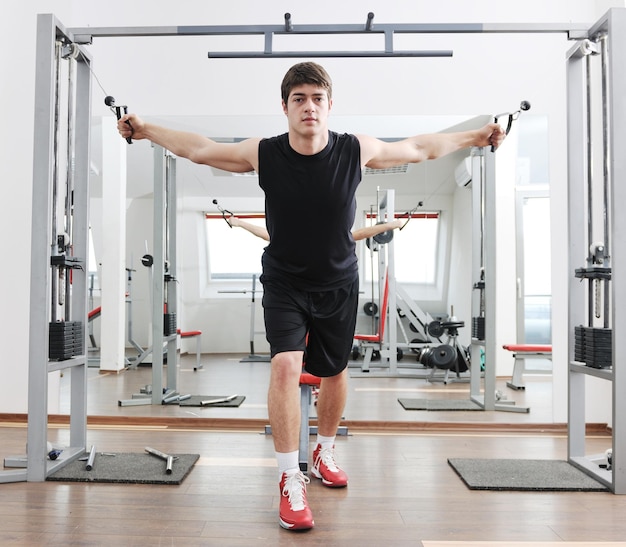 young man in fintess sport club exercise withweights and relaxing