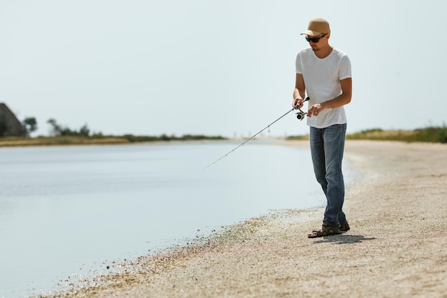 海で釣りをする若い男