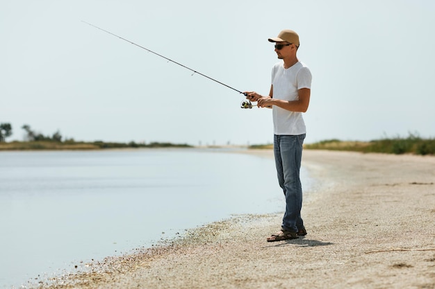 海で釣りをする若い男