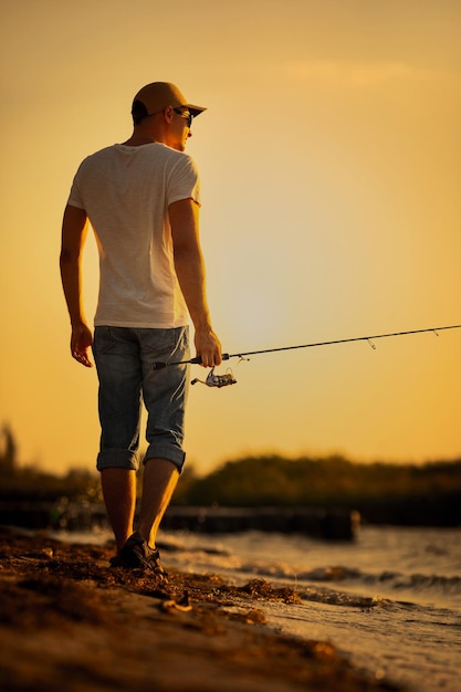 海で釣りをする若い男