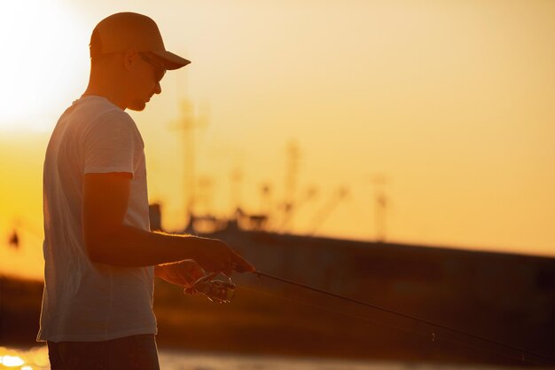 海で釣りをする若い男