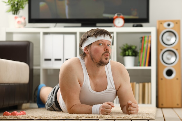 Young man fitness behind a desk is sending