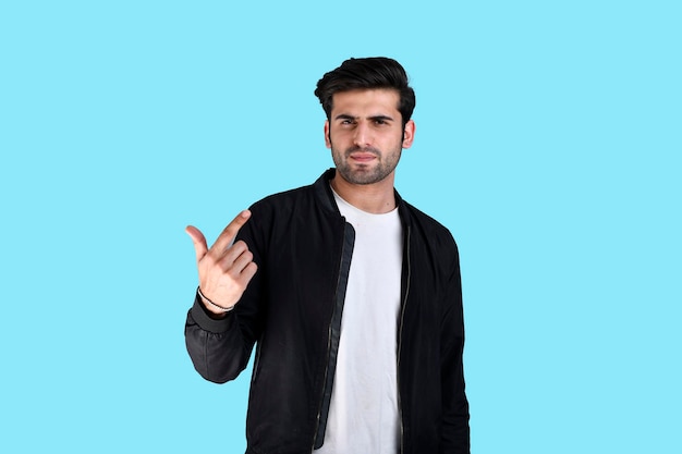 Young man front pose wearing winter clothes on blue background indian pakistani model