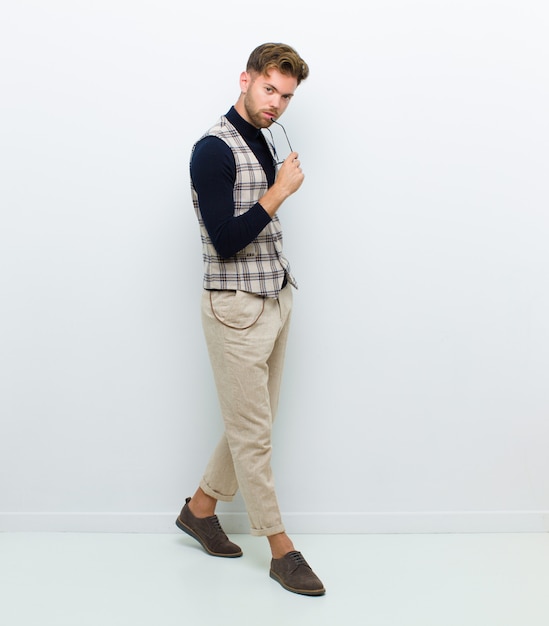 Young man full body posing against white wall